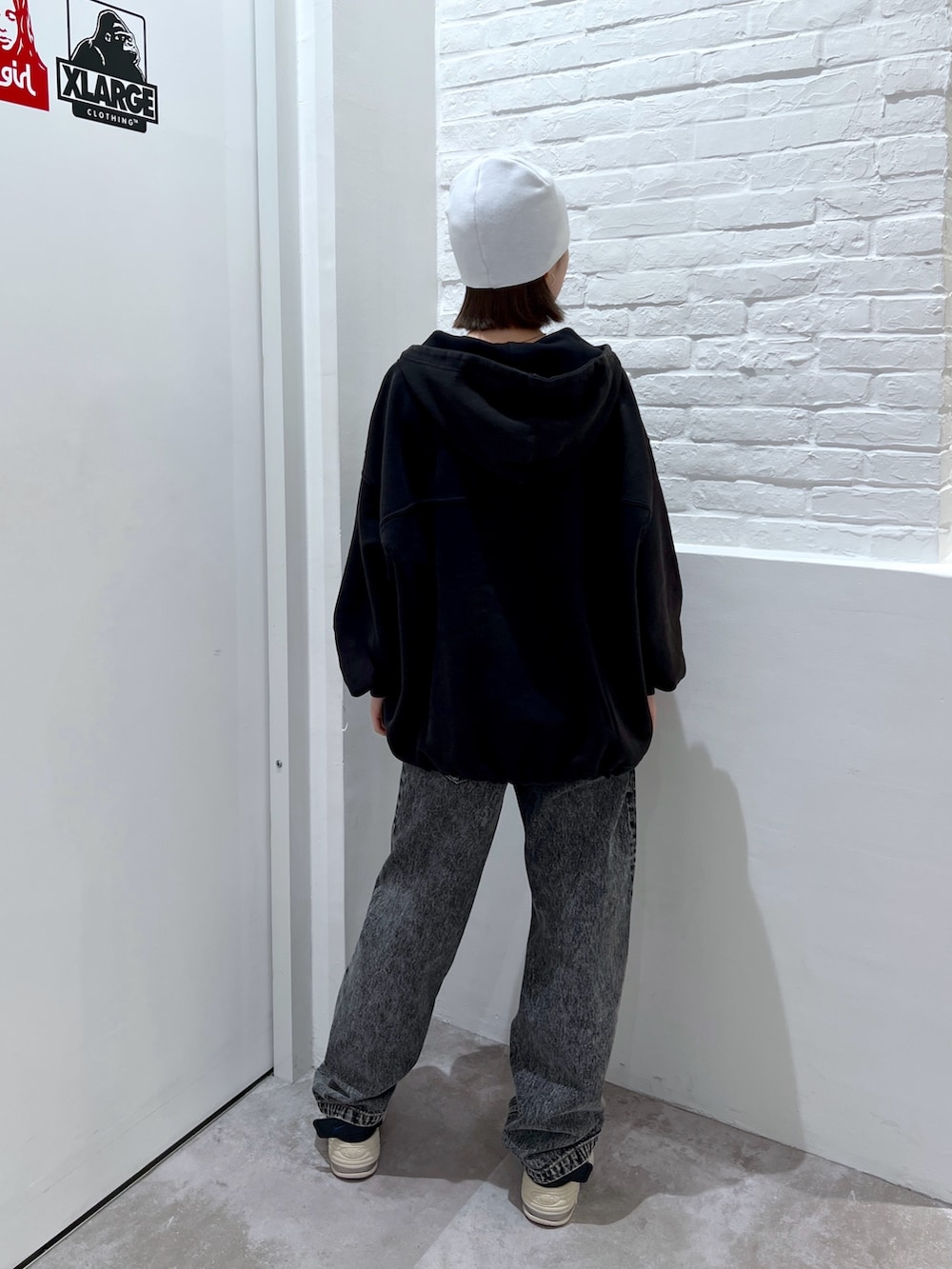 ブラック系のデニムパンツ、ブラック系のパーカー、ホワイト系のニットキャップ/ビーニーを着用したレディースの夏コーディネートの2枚目の写真