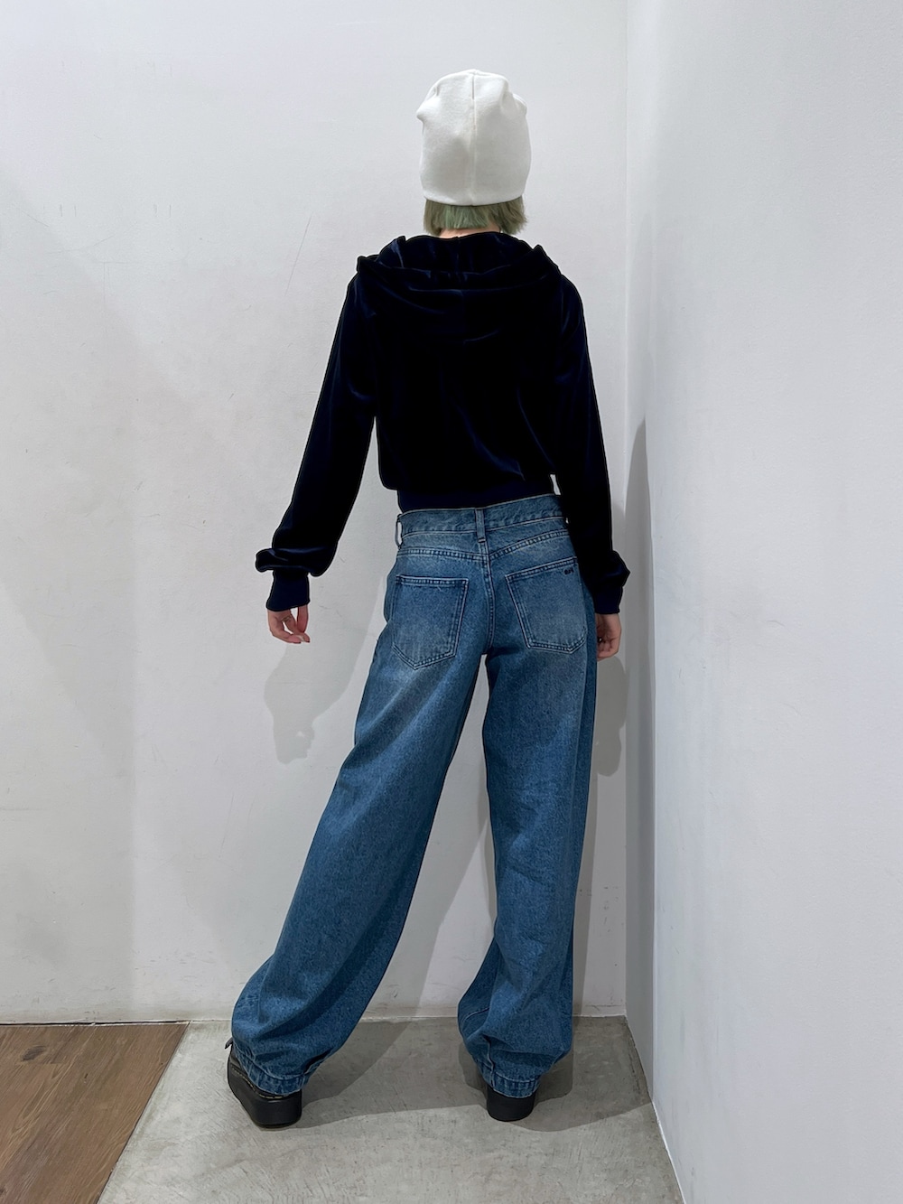 ブルー系のデニムパンツ、ブルー系のパーカー、ホワイト系のニットキャップ/ビーニーを着用したレディースの秋コーディネートの2枚目の写真