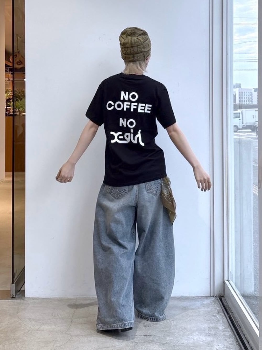 ブルー系のデニムパンツ、ブラック系のTシャツ/カットソー、ブラウン系のバンダナ/スカーフを着用したレディースの夏コーディネートの2枚目の写真