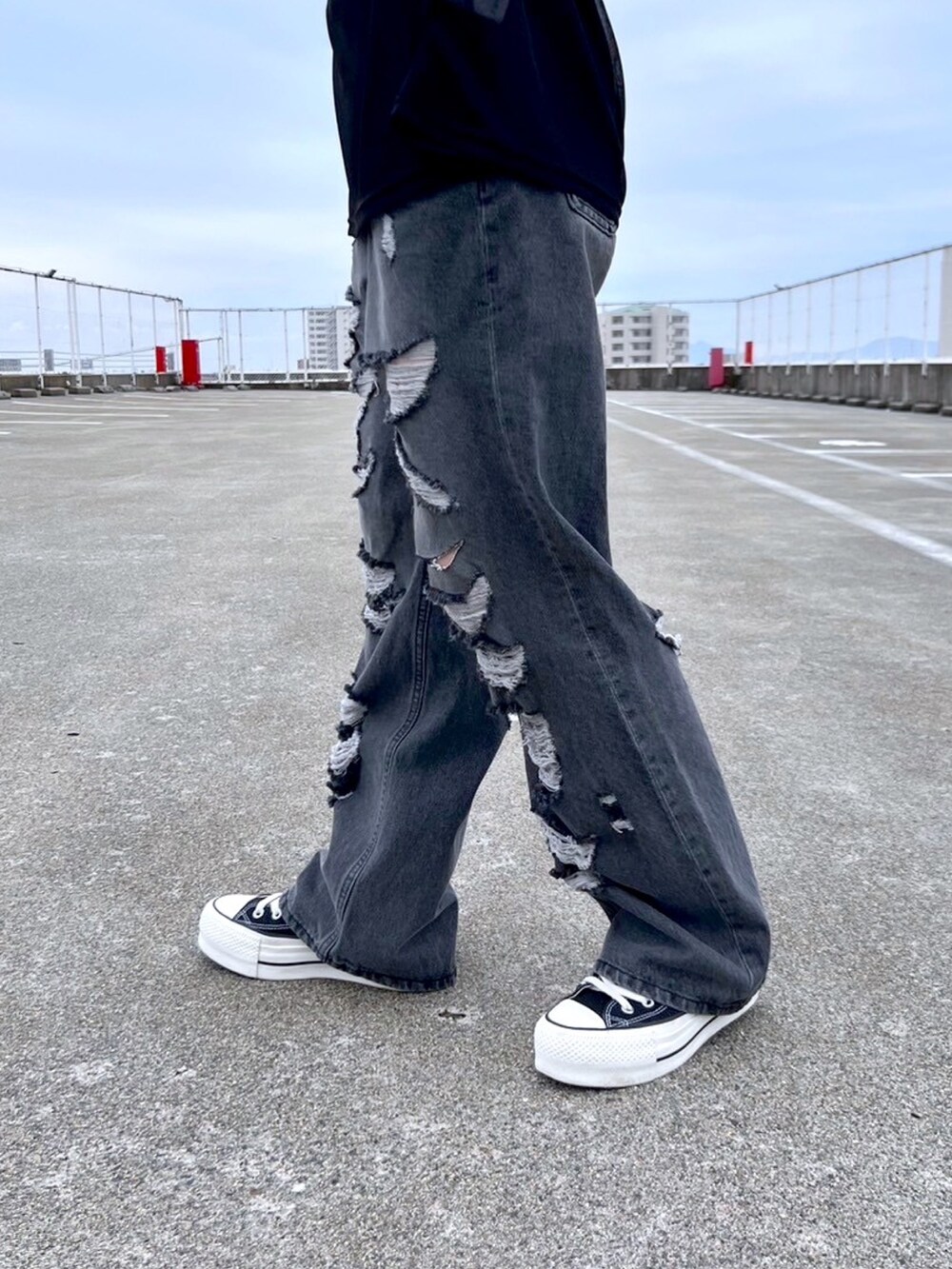 ブラック系のデニムパンツ、ブラック系のTシャツ/カットソー、ホワイト系のタンクトップを着用したレディースの夏コーディネートの5枚目の写真