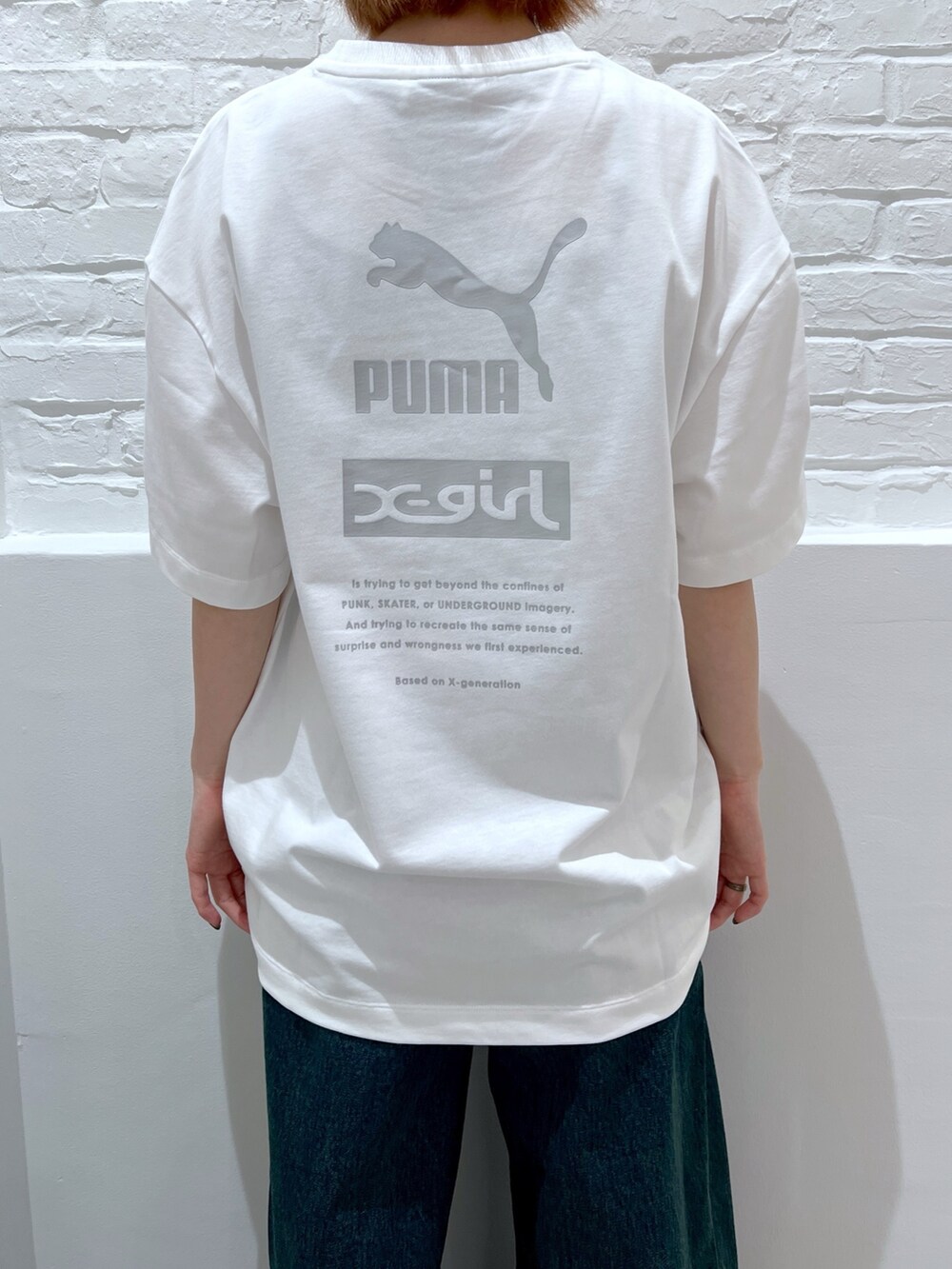 ブルー系のデニムパンツ、ホワイト系のTシャツ/カットソー、ベージュ系のハットを着用したレディースの春コーディネートの4枚目の写真