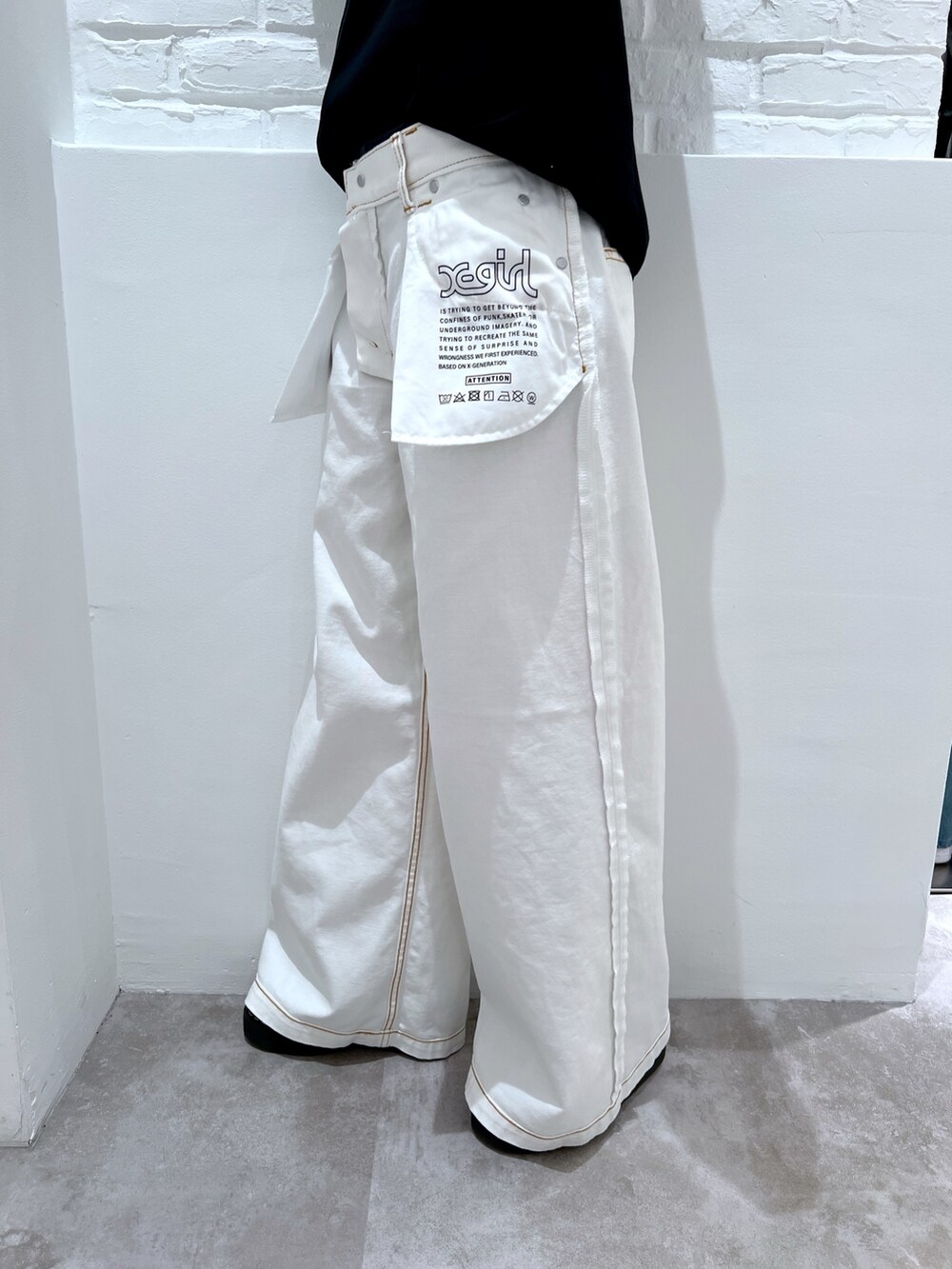 ホワイト系のデニムパンツ、ブラック系のTシャツ/カットソー、ベージュ系のニットキャップ/ビーニーを着用したレディースの春コーディネートの7枚目の写真