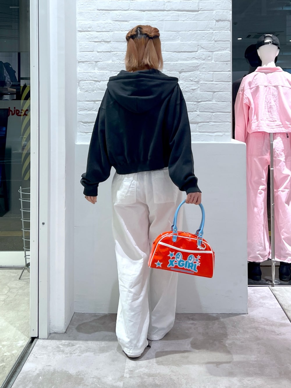 ブラック系のパーカー、レッド系のショルダーバッグ、ホワイト系のその他パンツを着用したレディースの春コーディネートの2枚目の写真