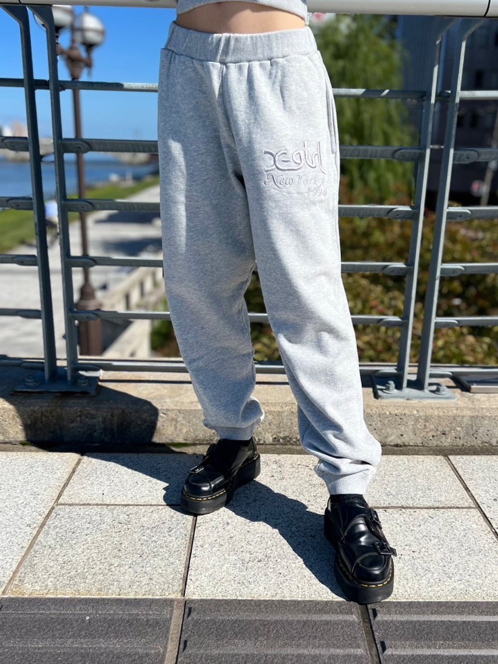 グレー系のスウェットパンツ、グレー系のパーカー、ブラック系のスタジャンを着用したレディースの秋コーディネートの4枚目の写真