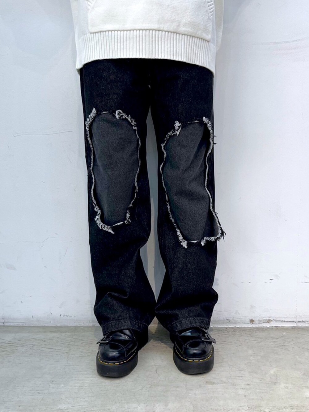 ブラック系のデニムパンツ、ピンク系のショルダーバッグ、ホワイト系のニット/セーターを着用したレディースの冬コーディネートの4枚目の写真