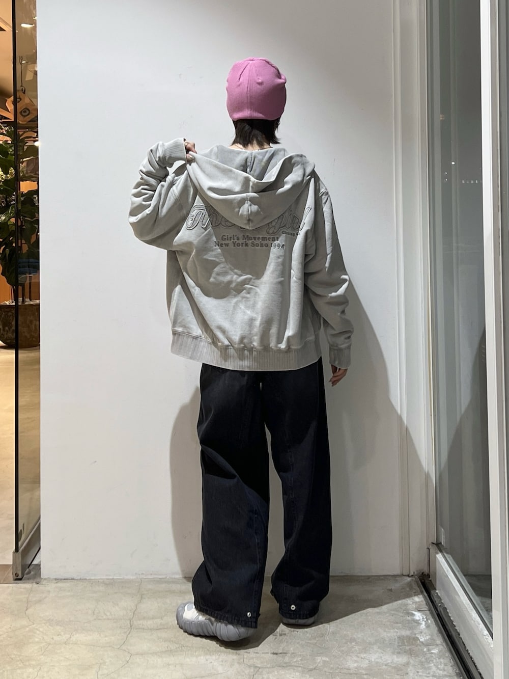 ブラック系のデニムパンツ、ホワイト系のTシャツ/カットソー、グレー系のパーカーを着用したレディースの冬コーディネートの2枚目の写真