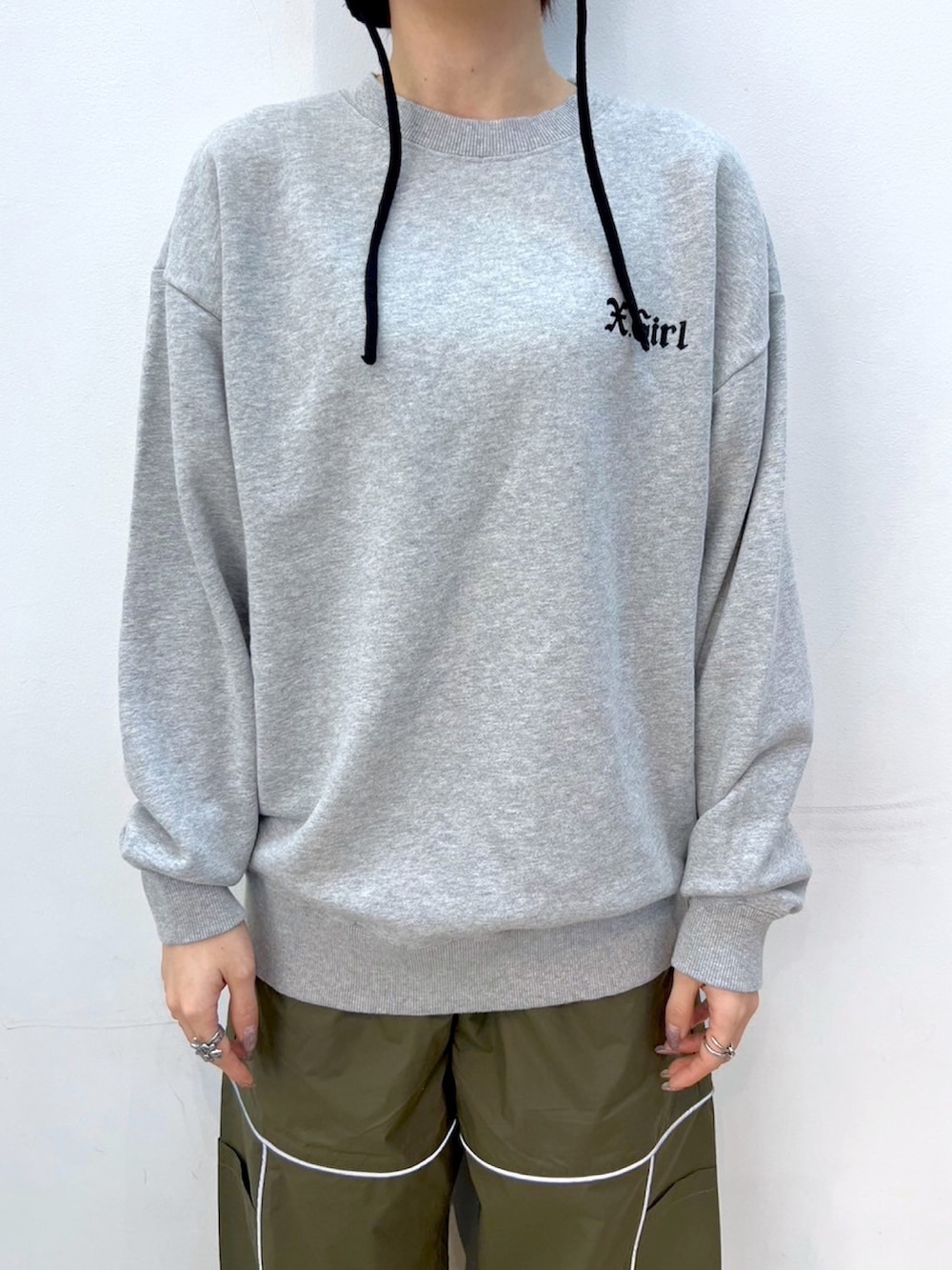 グレー系のスウェット、グリーン系のその他パンツ、ブラック系のニットキャップ/ビーニーを着用したレディースの冬コーディネートの3枚目の写真