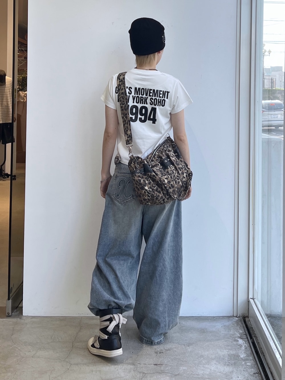 ブルー系のデニムパンツ、ベージュ系のショルダーバッグ、ホワイト系のTシャツ/カットソーを着用したレディースの夏コーディネートの3枚目の写真