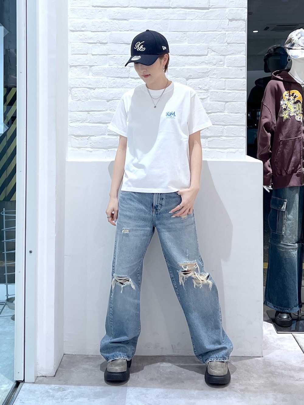ホワイト系のTシャツ/カットソー、ブルー系のデニムパンツ、ブルー系のキャップを着用したレディースの春コーディネートの2枚目の写真
