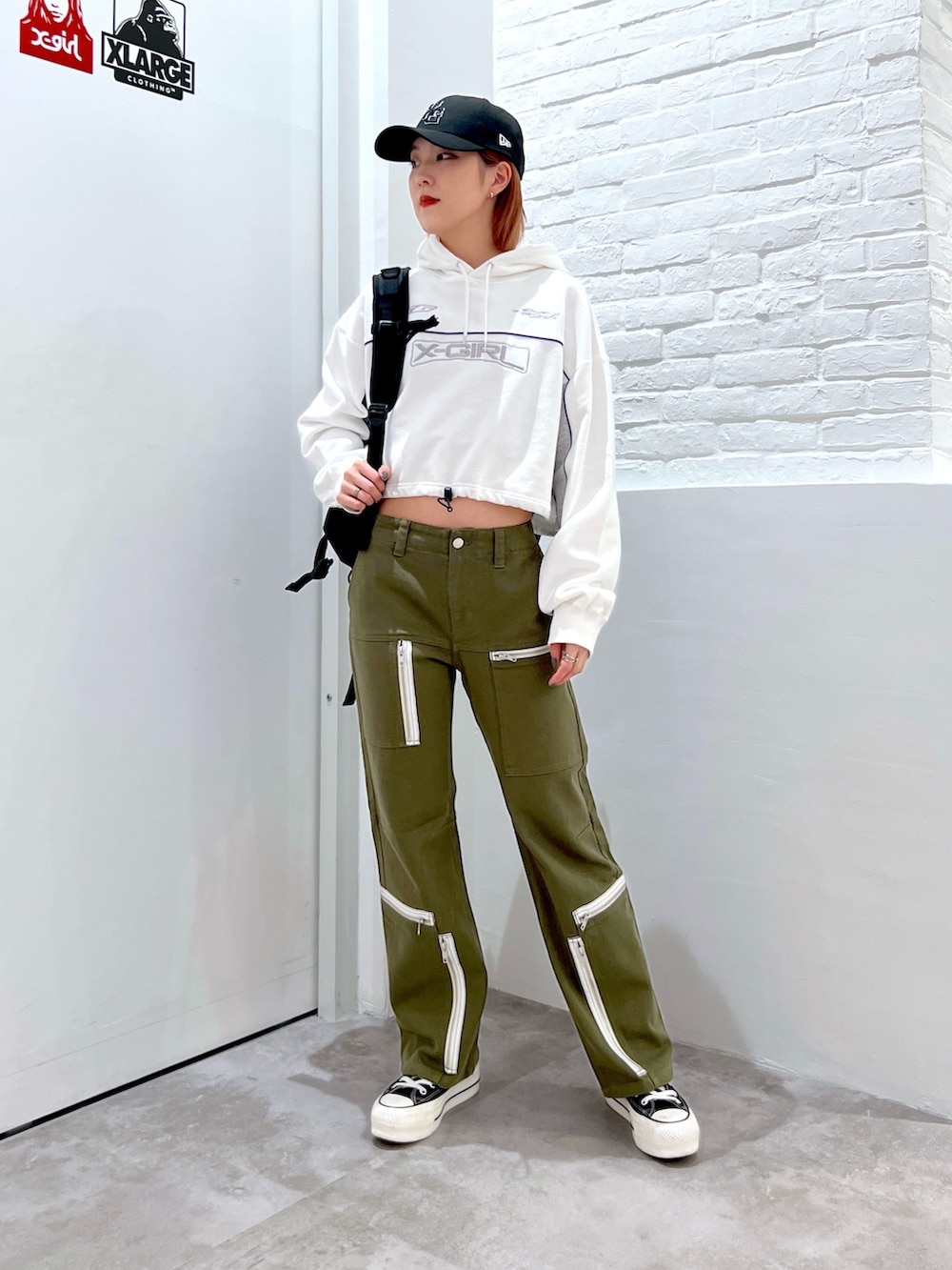 グリーン系のその他パンツ、ホワイト系のパーカー、ブラック系のバックパック/リュックを着用したレディースの冬コーディネートの2枚目の写真