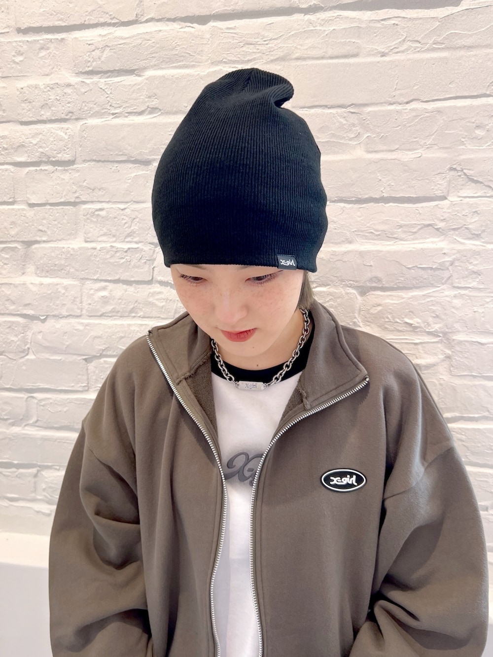 ブルー系のデニムパンツ、ホワイト系のTシャツ/カットソー、グリーン系のスウェットを着用したレディースの春コーディネートの5枚目の写真