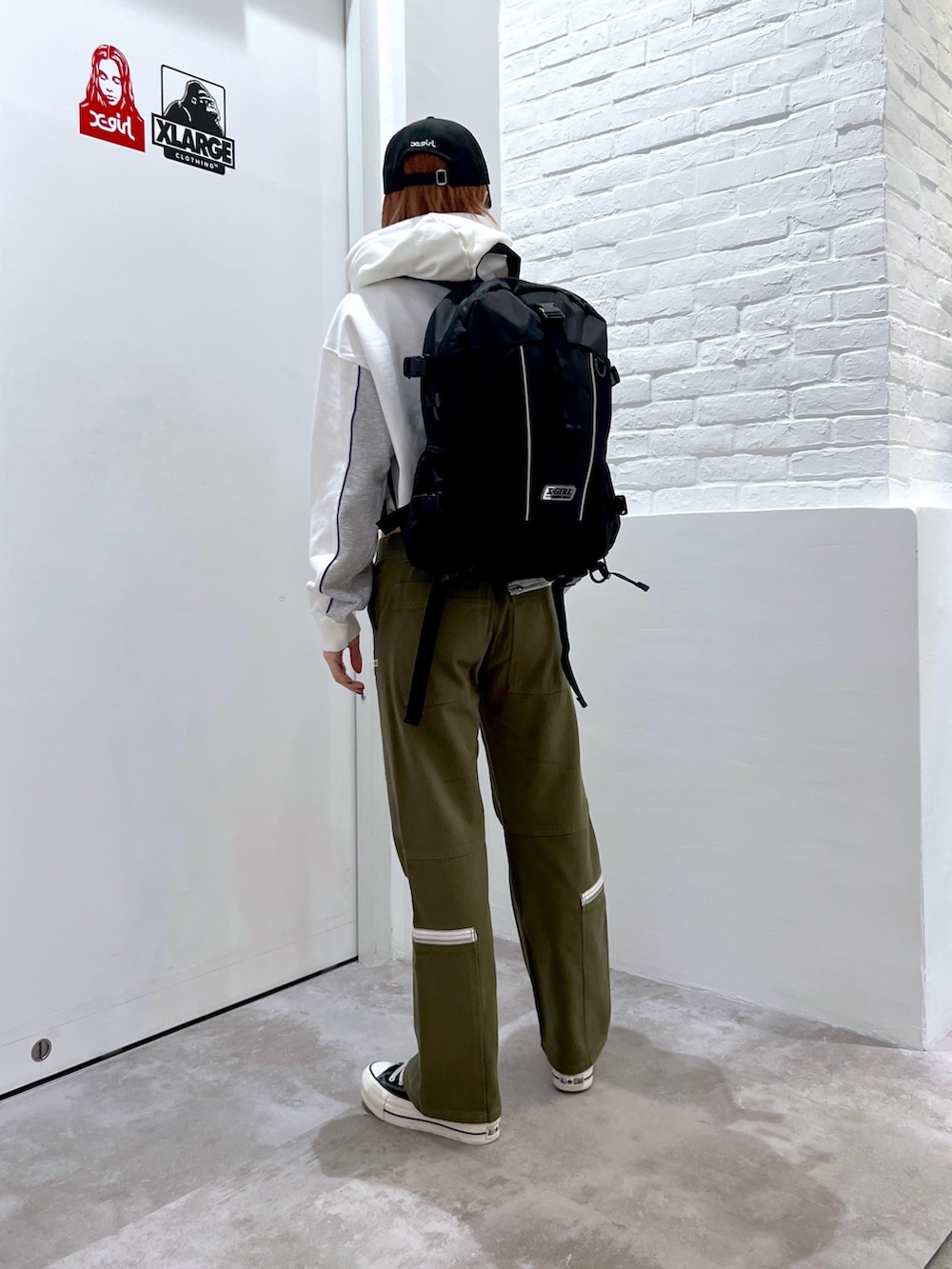 グリーン系のその他パンツ、ホワイト系のパーカー、ブラック系のバックパック/リュックを着用したレディースの冬コーディネートの3枚目の写真