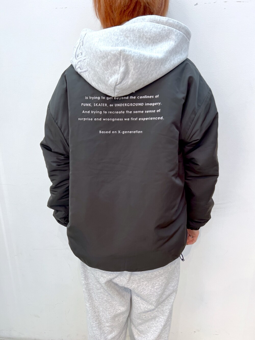 グレー系のパーカー、グレー系のスウェットパンツ、ピンク系のハンドバッグを着用したレディースの冬コーディネートの5枚目の写真