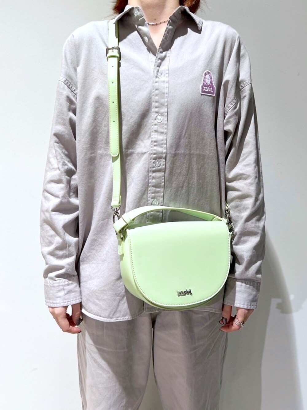 グレー系のその他パンツ、グレー系のシャツ/ブラウス、グリーン系のショルダーバッグを着用したレディースの春コーディネートの3枚目の写真