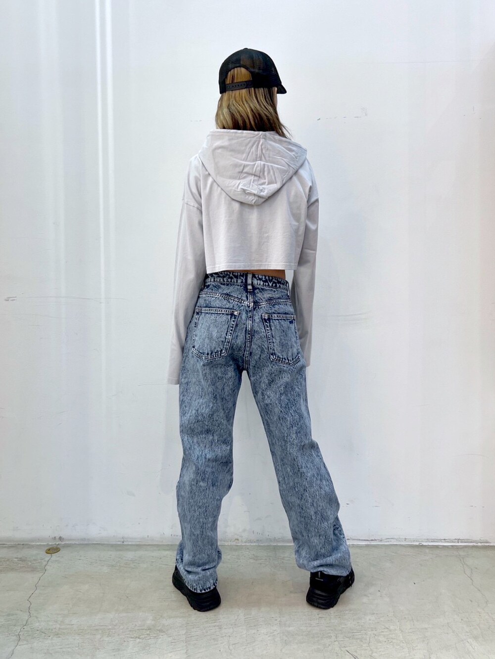 ブルー系のデニムパンツ、グレー系のパーカー、ブラック系のキャップを着用したレディースの夏コーディネートの2枚目の写真