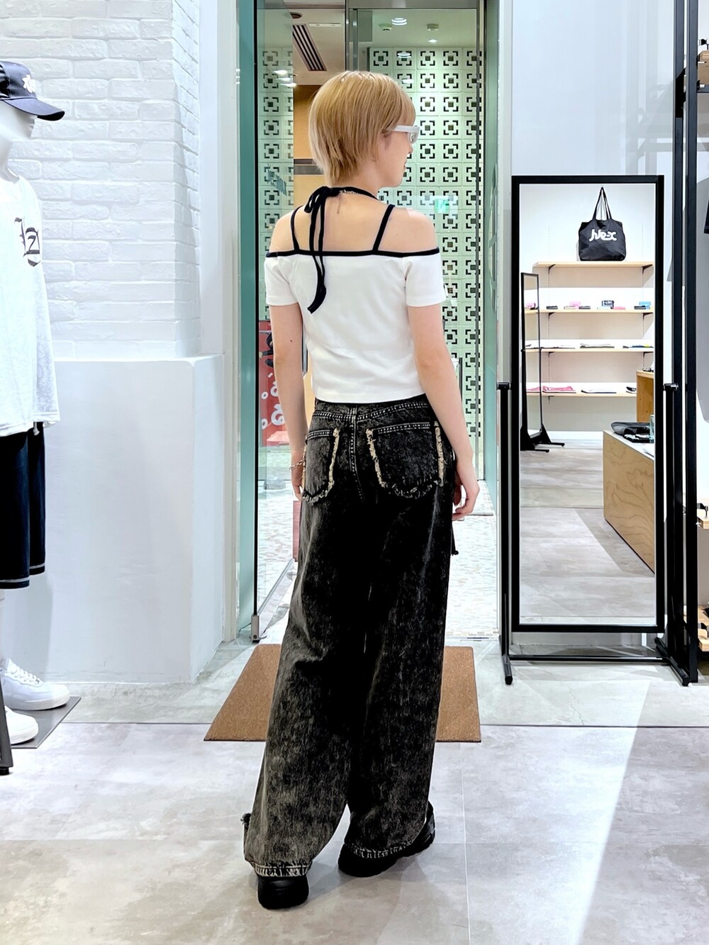 ブラック系のデニムパンツ、ホワイト系のTシャツ/カットソー、ホワイト系のサングラスを着用したレディースの夏コーディネートの2枚目の写真