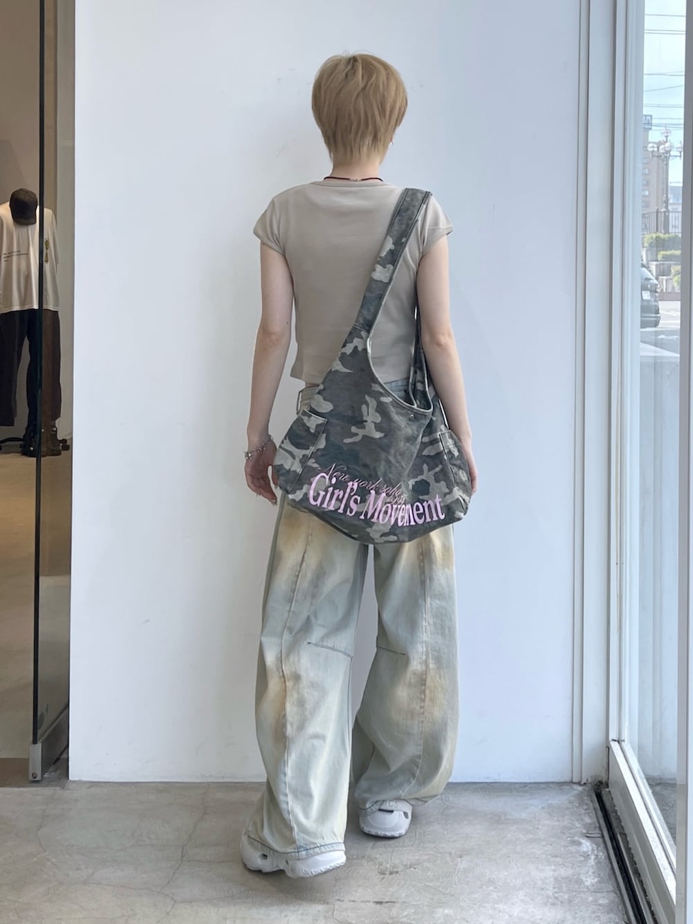 ブルー系のデニムパンツ、その他のショルダーバッグ、ベージュ系のTシャツ/カットソーを着用したレディースの夏コーディネートの2枚目の写真