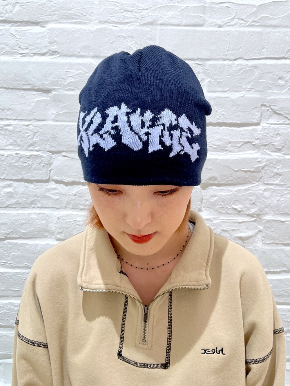 ブルー系のデニムパンツ、ベージュ系のスウェット、ブルー系のニットキャップ/ビーニーを着用したレディースの春コーディネートの6枚目の写真