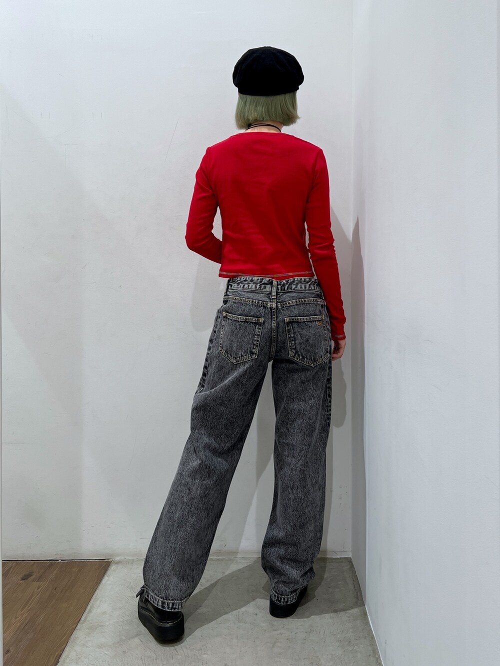 ブラック系のデニムパンツ、レッド系のTシャツ/カットソー、ブラック系のキャスケットを着用したレディースの秋コーディネートの2枚目の写真