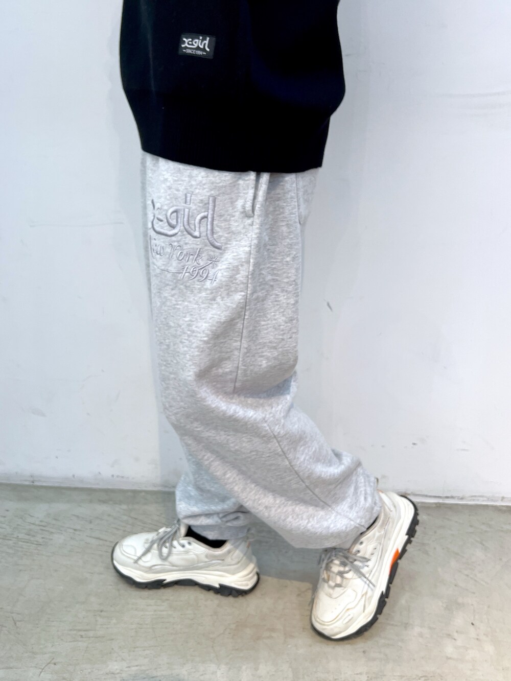 ブラック系のニット/セーター、グレー系のスウェットパンツ、ピンク系のショルダーバッグを着用したレディースの秋コーディネートの5枚目の写真