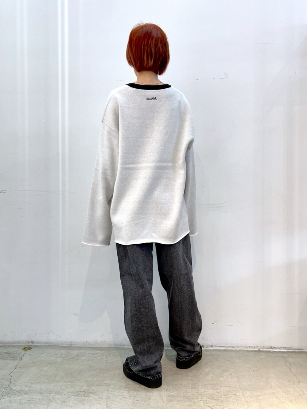 ブラック系のデニムパンツ、ホワイト系のニット/セーター、ブラック系のブルゾンを着用したレディースの冬コーディネートの4枚目の写真