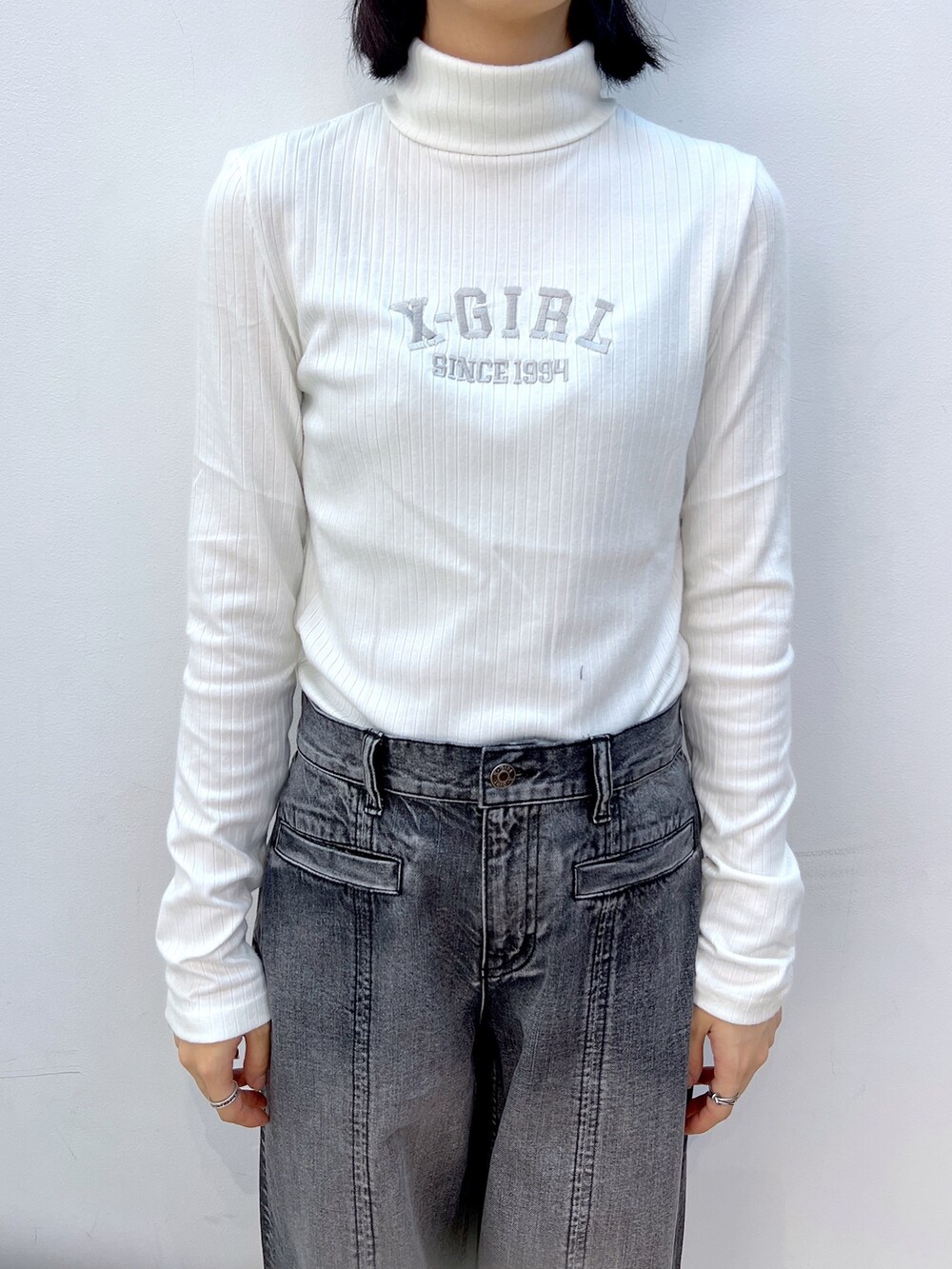 ホワイト系のTシャツ/カットソー、パープル系のショルダーバッグ、ブラック系のデニムパンツを着用したレディースの秋コーディネートの3枚目の写真