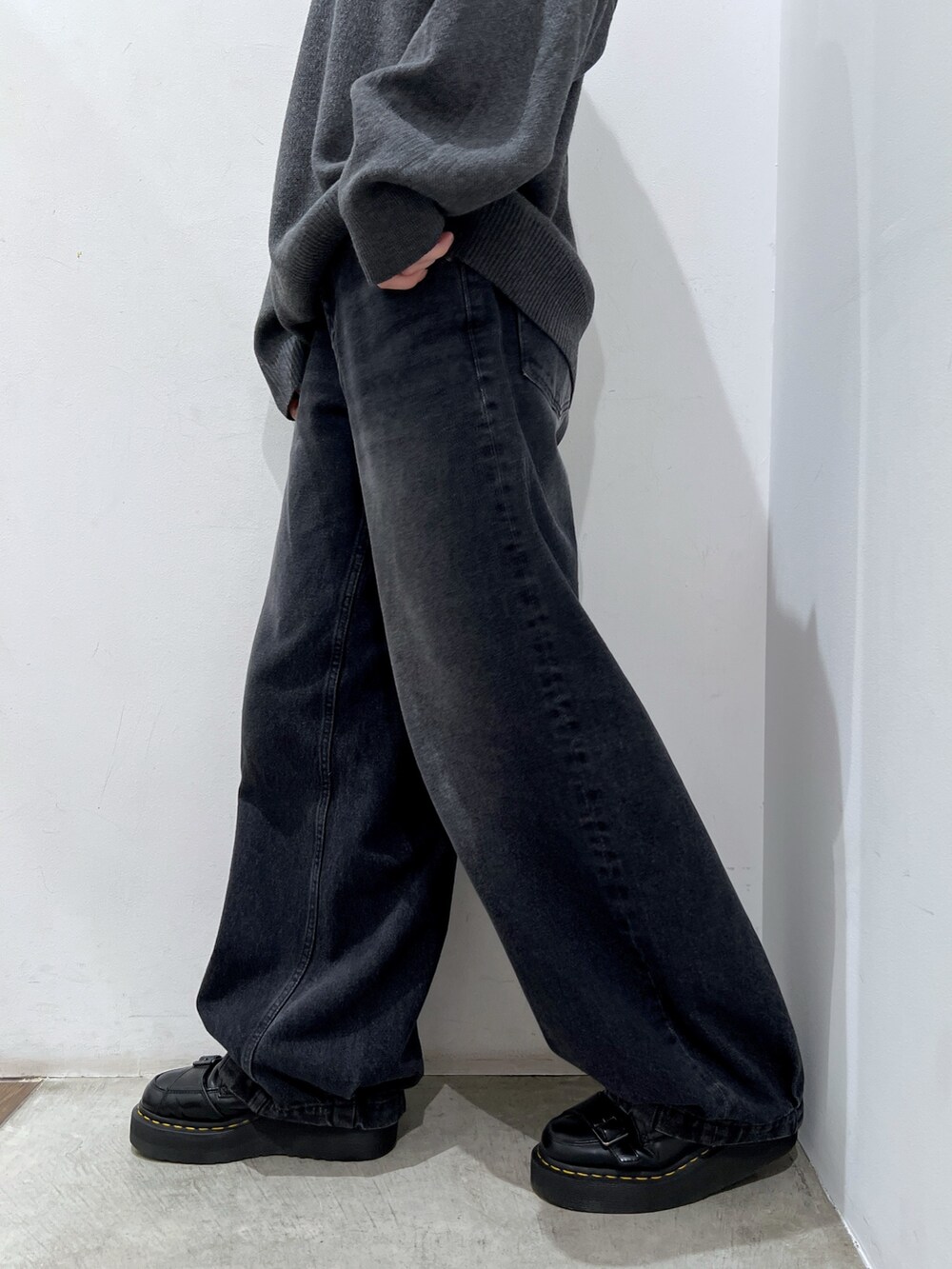 ホワイト系のショルダーバッグ、ブラック系のデニムパンツ、グレー系のニット/セーターを着用したレディースの秋コーディネートの7枚目の写真