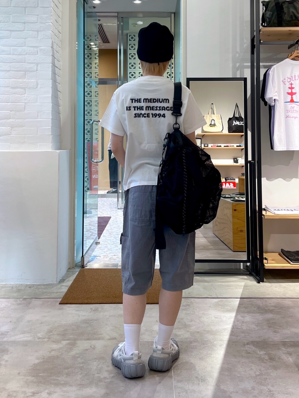 グレー系のその他パンツ、ホワイト系のTシャツ/カットソー、ブラック系のバックパック/リュックを着用したレディースの夏コーディネートの3枚目の写真