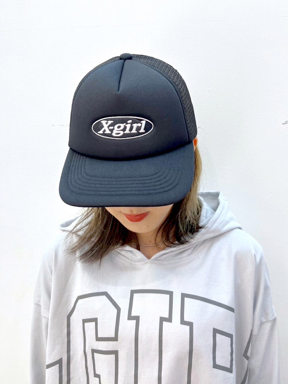 ブルー系のデニムパンツ、グレー系のパーカー、ブラック系のキャップを着用したレディースの夏コーディネートの5枚目の写真