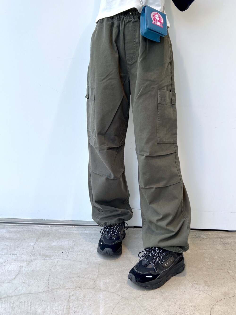 グリーン系のその他パンツ、ブルー系のショルダーバッグ、ホワイト系のTシャツ/カットソーを着用したレディースの秋コーディネートの5枚目の写真