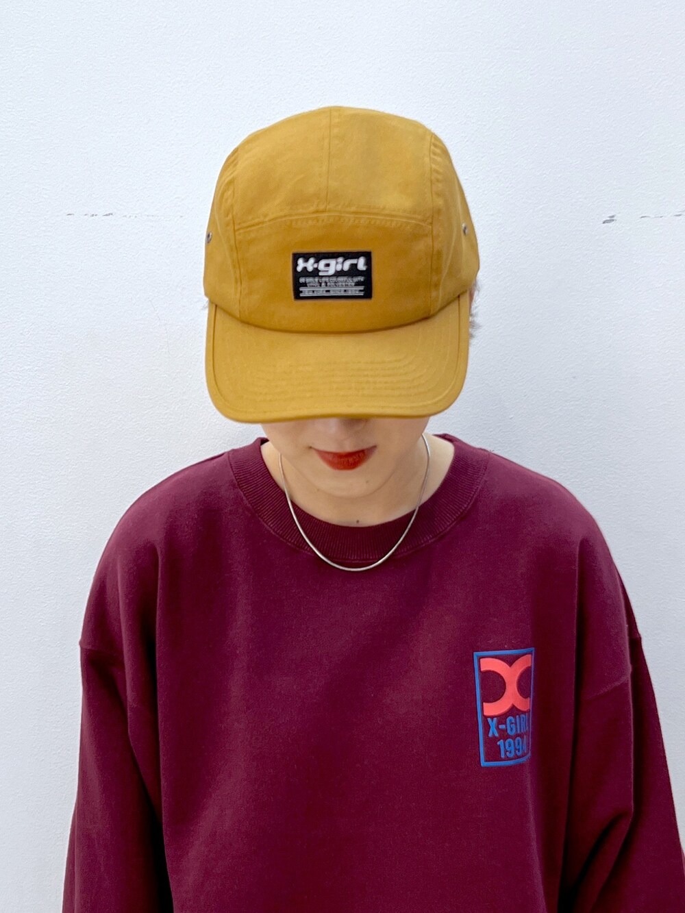 レッド系のスウェット、ブラック系のスウェットパンツ、ブラック系のスニーカーを着用したレディースの秋コーディネートの6枚目の写真