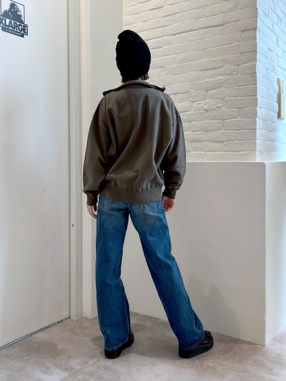 ブルー系のデニムパンツ、ホワイト系のTシャツ/カットソー、グリーン系のスウェットを着用したレディースの春コーディネートの2枚目の写真