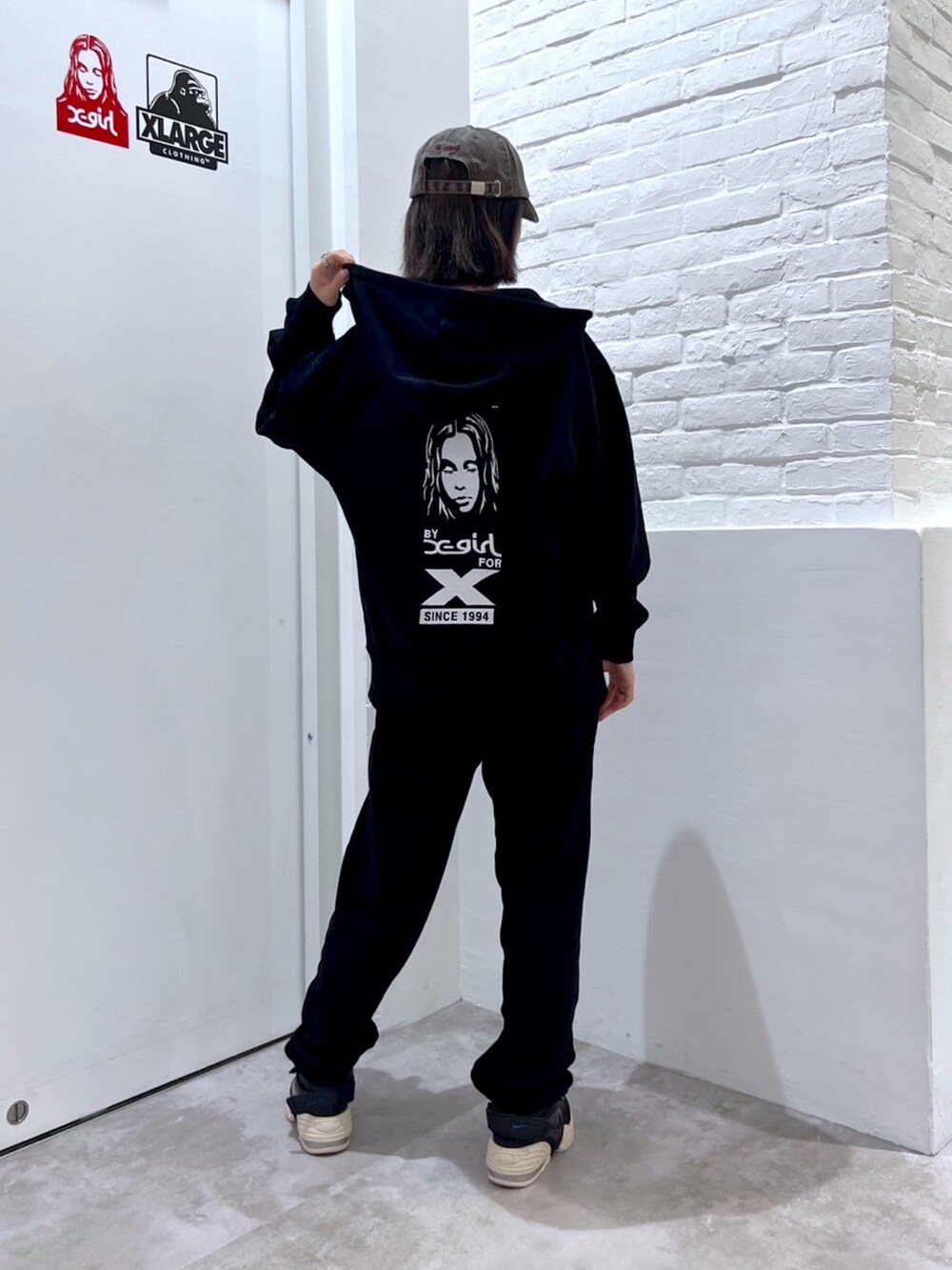 ブラック系のスウェットパンツ、ホワイト系のTシャツ/カットソー、ブラック系のパーカーを着用したレディースの秋コーディネートの2枚目の写真