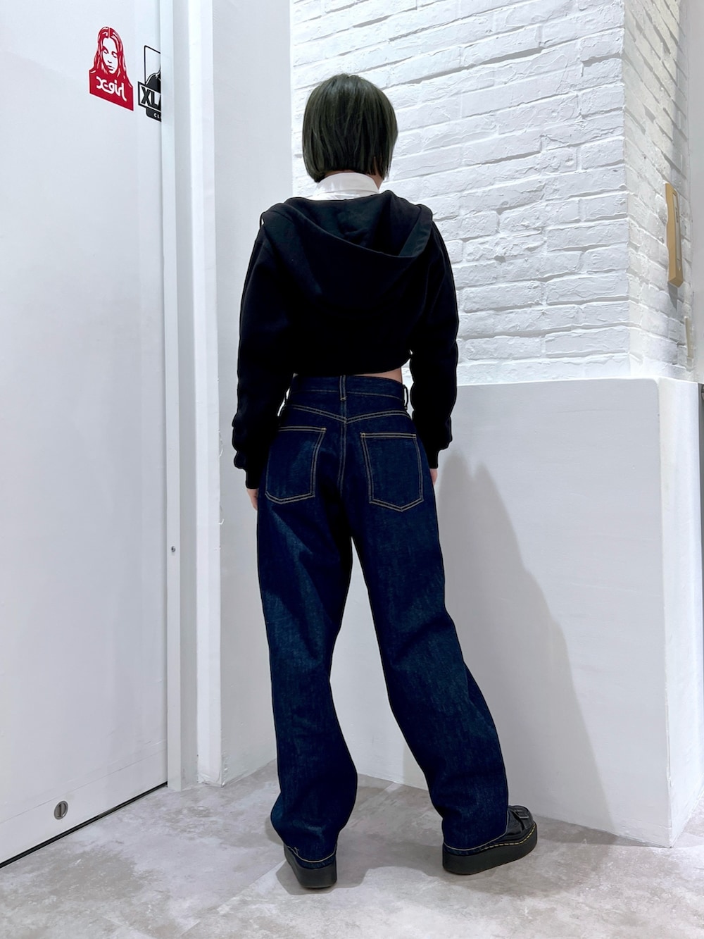 ブルー系のデニムパンツ、ホワイト系のシャツ/ブラウス、ブラック系のパーカーを着用したレディースの春コーディネートの2枚目の写真