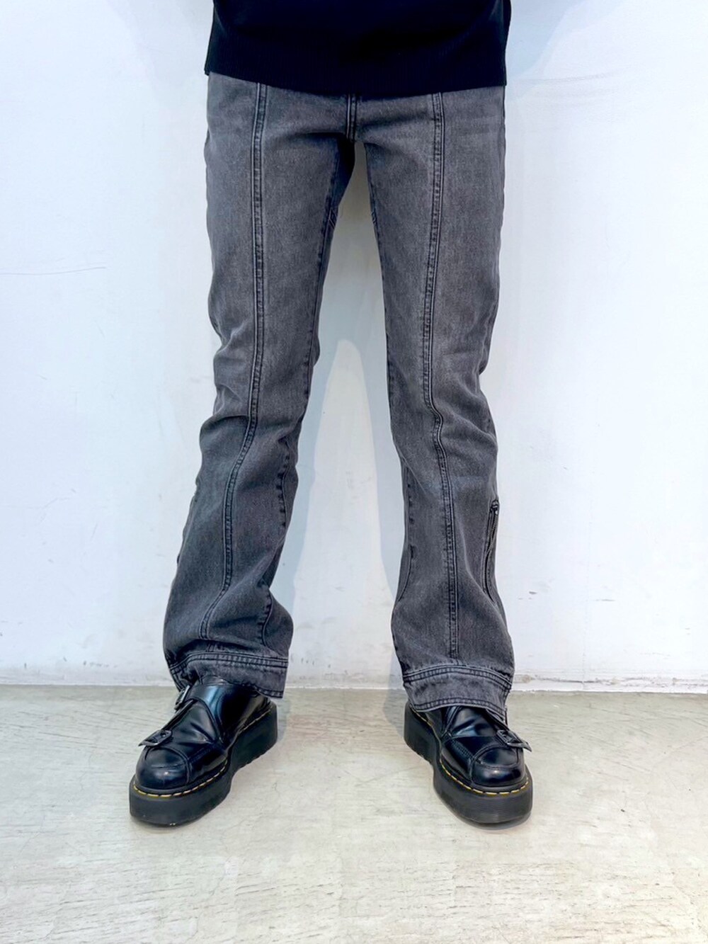 ブラック系のデニムパンツ、グレー系のマウンテンパーカー、ブラック系のニット/セーターを着用したレディースの秋コーディネートの6枚目の写真