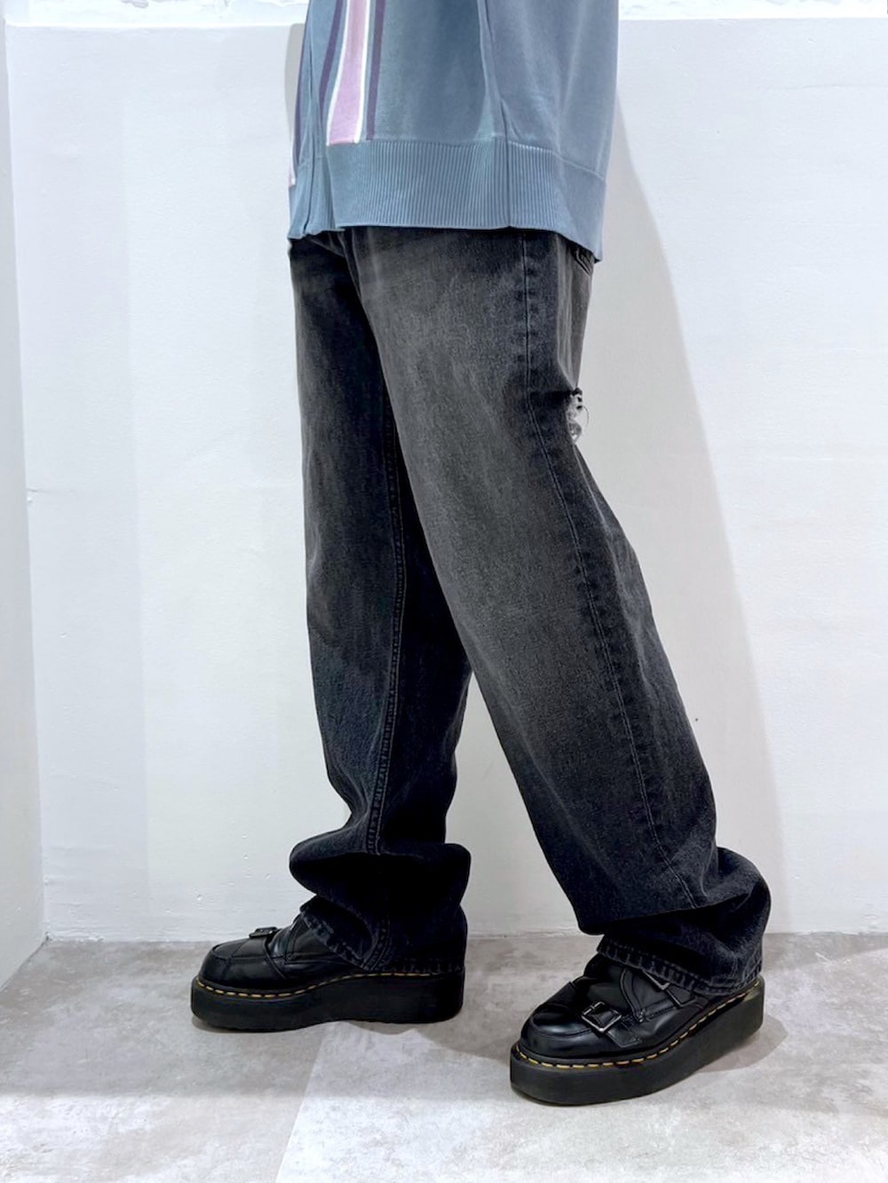 ブラック系のデニムパンツ、ブルー系のポロシャツ、ブラック系のニットキャップ/ビーニーを着用したレディースの春コーディネートの5枚目の写真