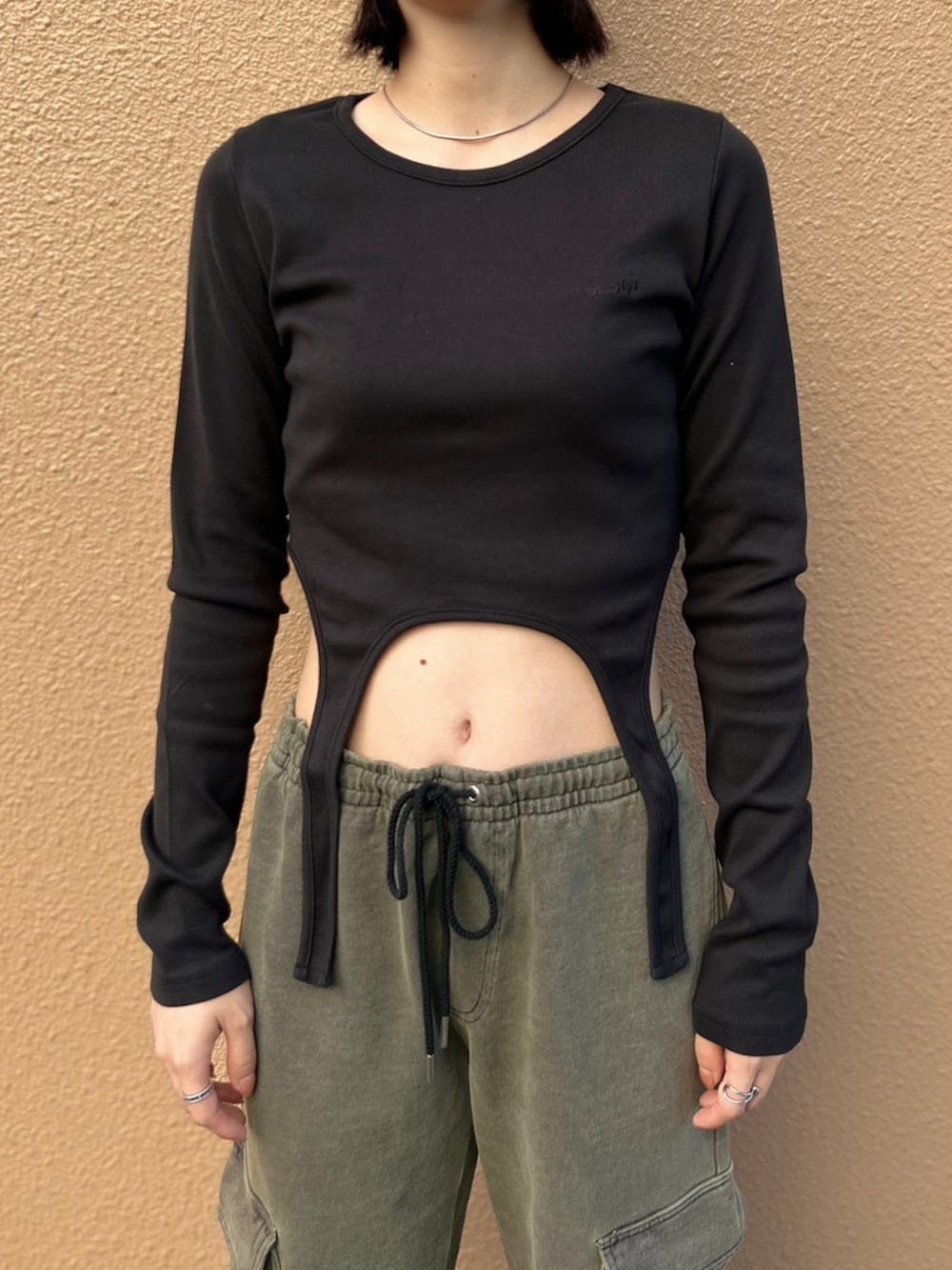 グリーン系のスウェットパンツ、ブラック系のTシャツ/カットソー、グレー系のニットキャップ/ビーニーを着用したレディースの秋コーディネートの3枚目の写真