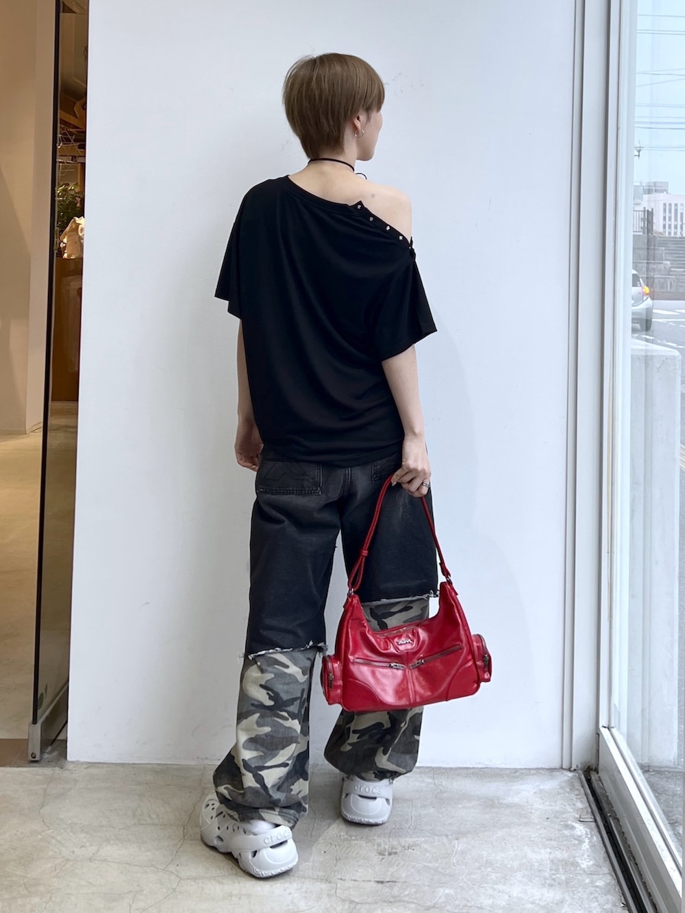 ブラック系のデニムパンツ、レッド系のショルダーバッグ、ブラック系のTシャツ/カットソーを着用したレディースの春コーディネートの2枚目の写真