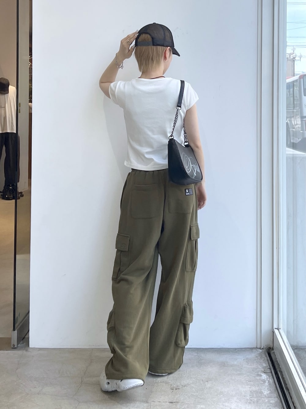 グリーン系のスウェットパンツ、ホワイト系のTシャツ/カットソー、ブラック系のショルダーバッグを着用したレディースの夏コーディネートの2枚目の写真