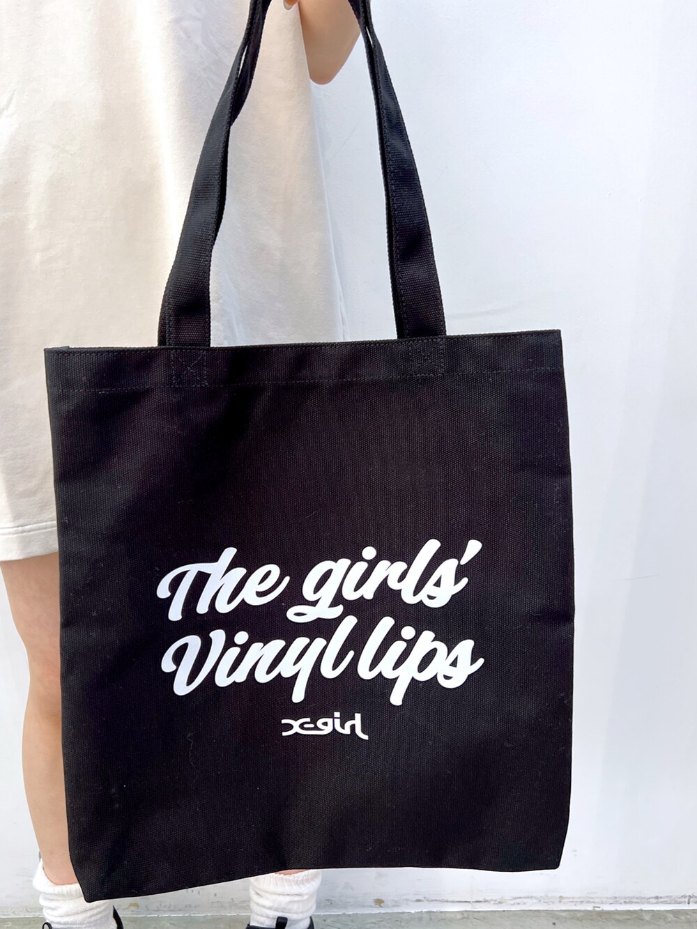 ホワイト系のワンピース、ブラック系のトートバッグ、グリーン系のキャップを着用したレディースの夏コーディネートの5枚目の写真