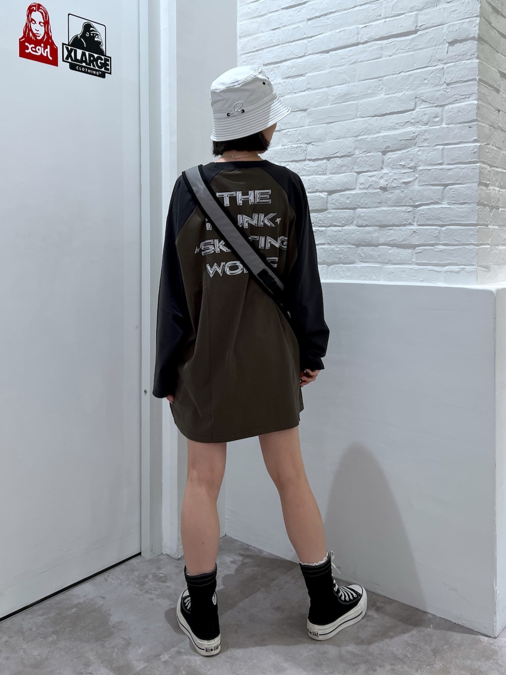 グリーン系のワンピース、グレー系のショルダーバッグ、ホワイト系のハットを着用したレディースの夏コーディネートの2枚目の写真