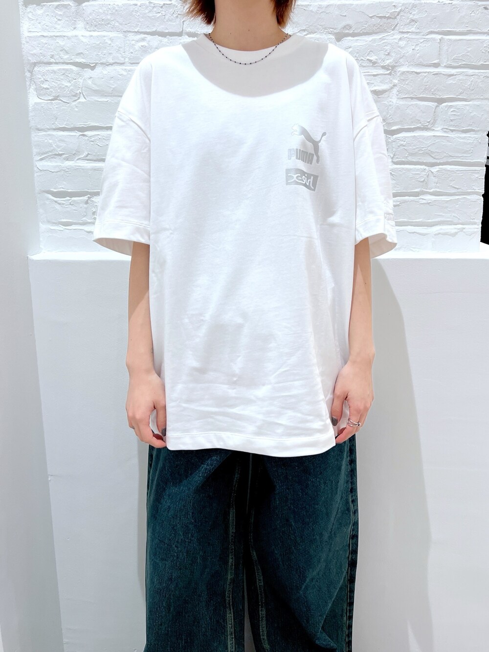 ブルー系のデニムパンツ、ホワイト系のTシャツ/カットソー、ベージュ系のハットを着用したレディースの春コーディネートの3枚目の写真