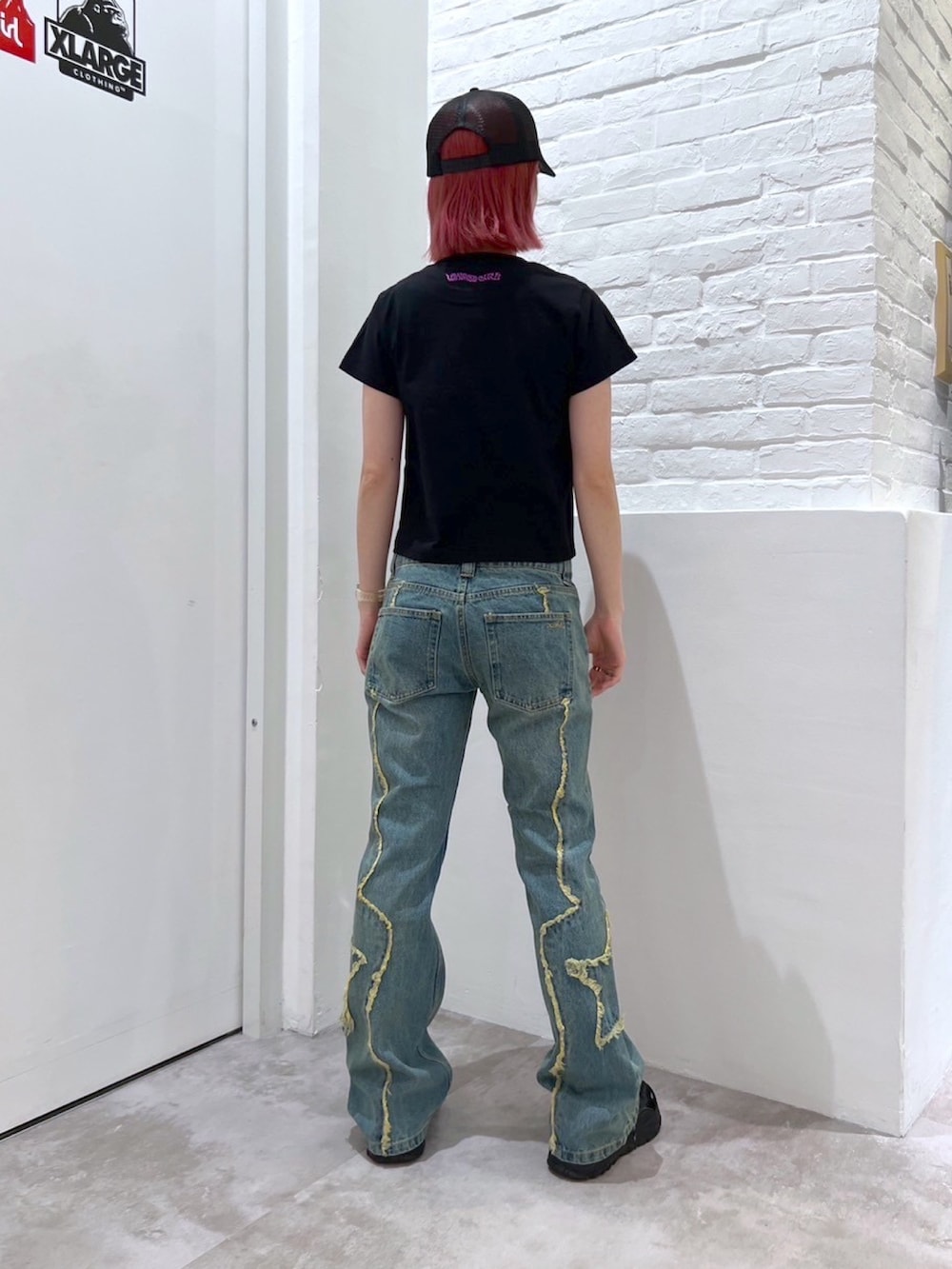 ブルー系のデニムパンツ、ブラック系のTシャツ/カットソー、シルバー系のネックレスを着用したレディースの春コーディネートの2枚目の写真