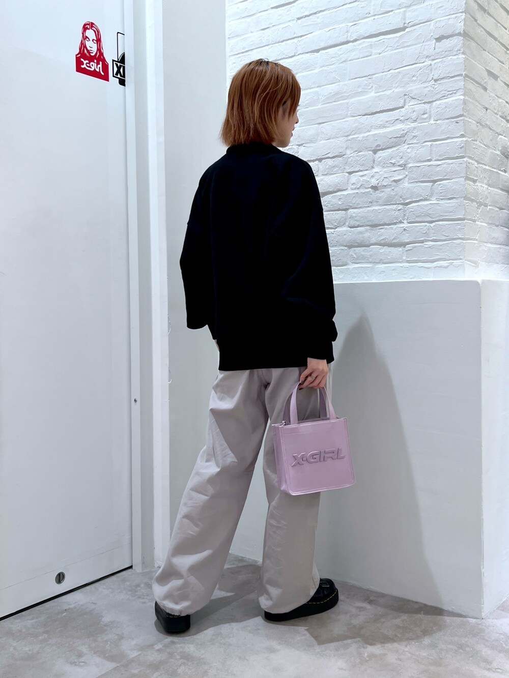 グレー系のその他パンツ、ブラック系のスウェット、ピンク系のショルダーバッグを着用したレディースの春コーディネートの2枚目の写真