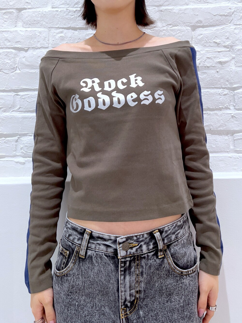 ブラック系のデニムパンツ、グリーン系のTシャツ/カットソー、ブラック系のニットキャップ/ビーニーを着用したレディースの秋コーディネートの3枚目の写真