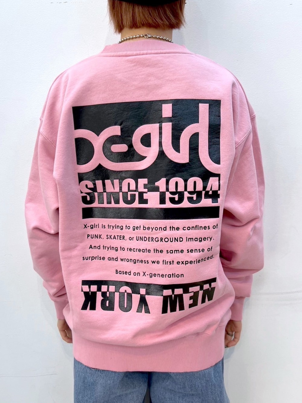 ピンク系のスウェット、ブルー系のデニムパンツ、ブラック系のニットキャップ/ビーニーを着用したレディースの冬コーディネートの4枚目の写真