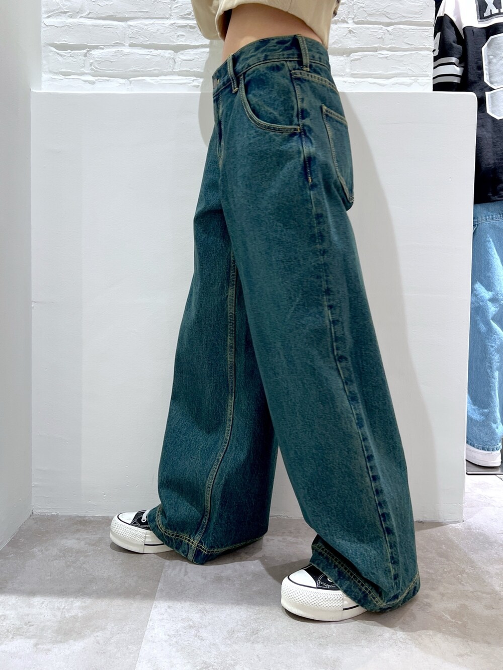 ブルー系のデニムパンツ、ベージュ系のスウェット、ブルー系のニットキャップ/ビーニーを着用したレディースの春コーディネートの5枚目の写真