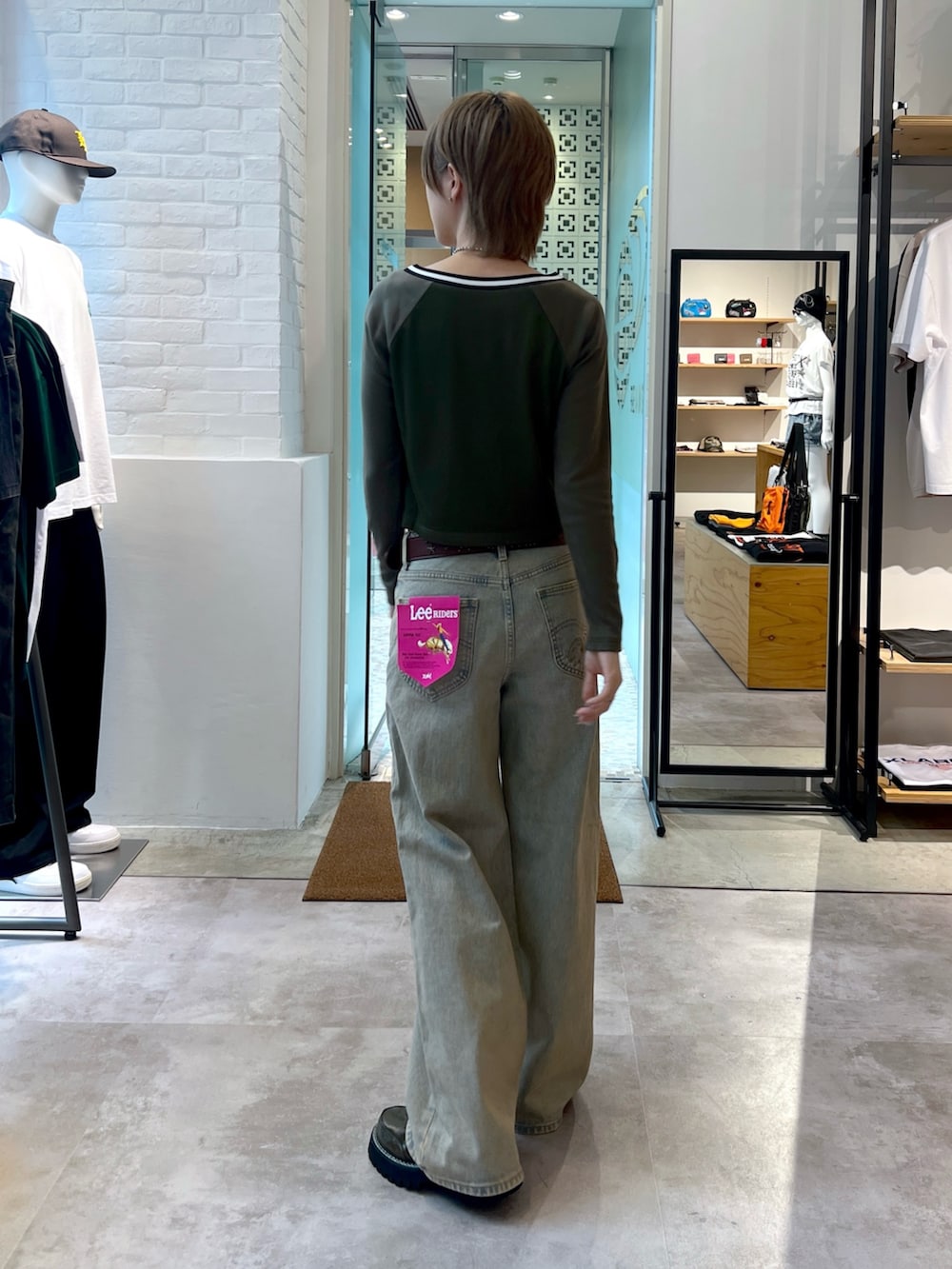 ブルー系のデニムパンツ、グリーン系のTシャツ/カットソー、ブラウン系のベルトを着用したレディースの夏コーディネートの2枚目の写真
