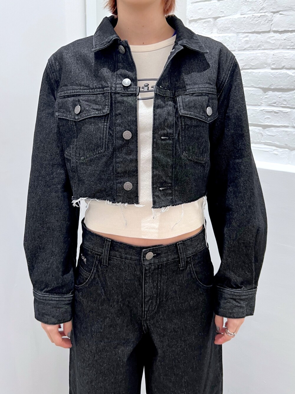 ブラック系のデニムパンツ、ホワイト系のTシャツ/カットソー、ブラック系のデニムジャケットを着用したレディースの冬コーディネートの3枚目の写真