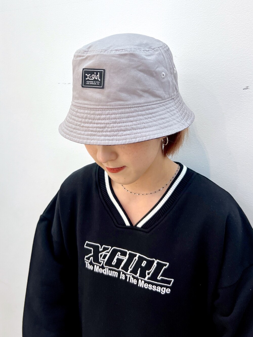 ブラック系のデニムパンツ、ブラック系のスウェット、ブルー系のハットを着用したレディースの冬コーディネートの6枚目の写真